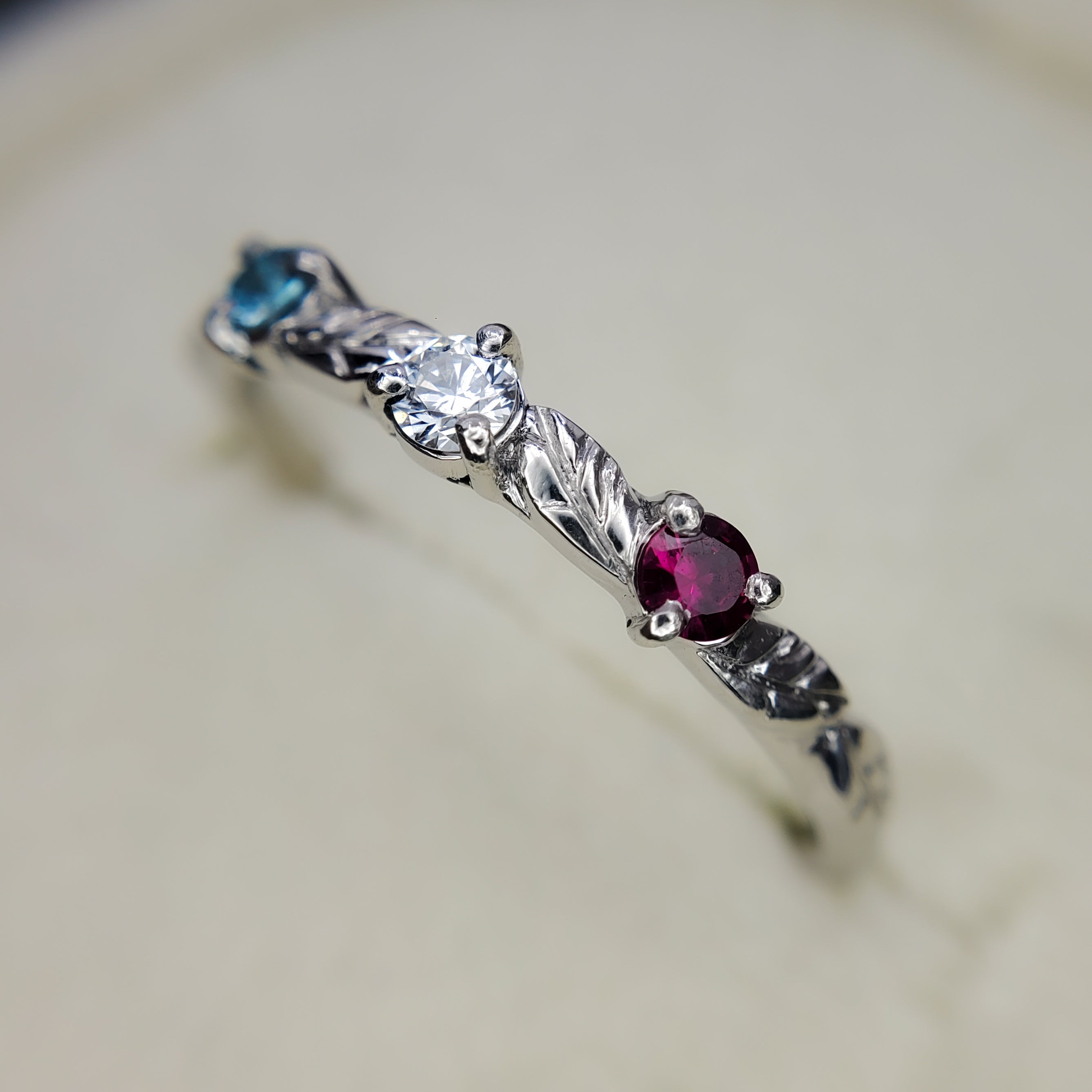 Platinum ring with engraved leaves and gemstones.