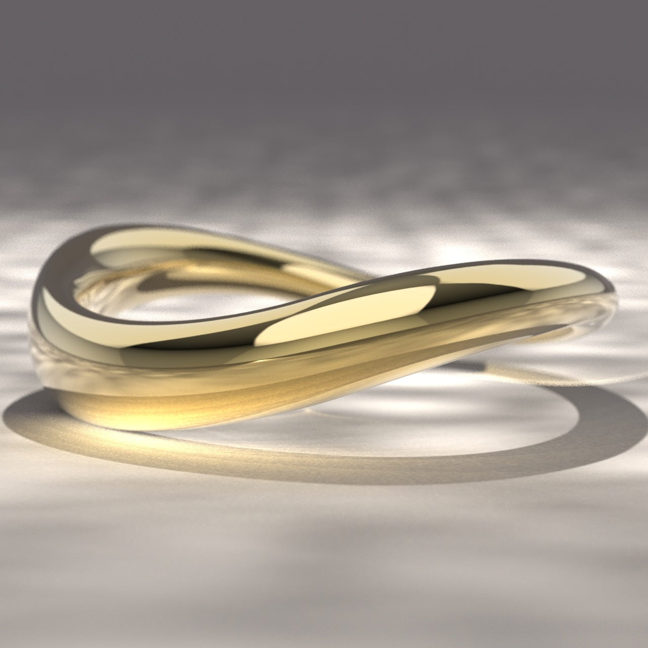 Gold ring with a wavy design on a reflective surface