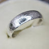 Silver ring with a textured surface on a white background